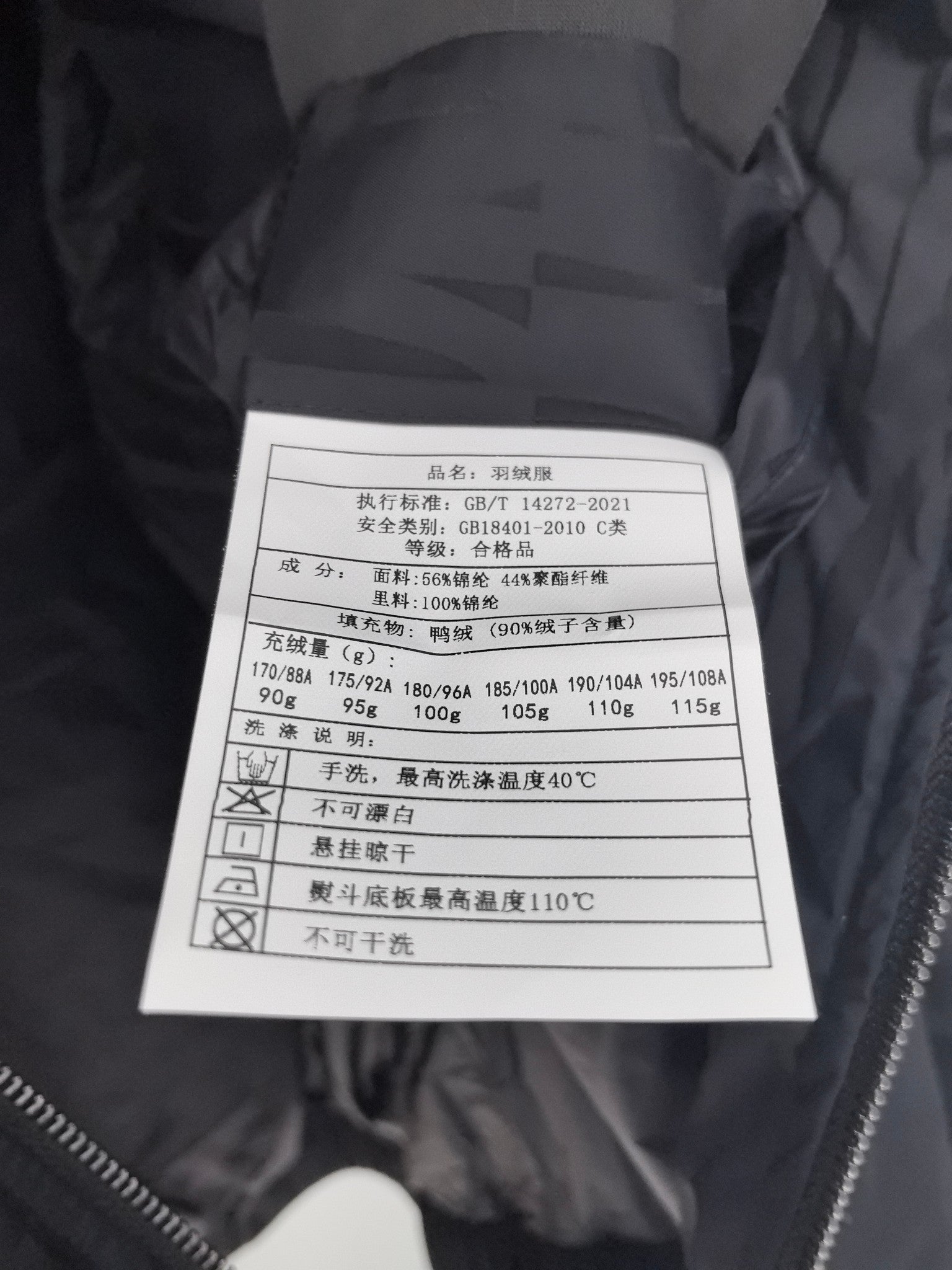 Prada puffer jacket care label with washing and fabric instructions