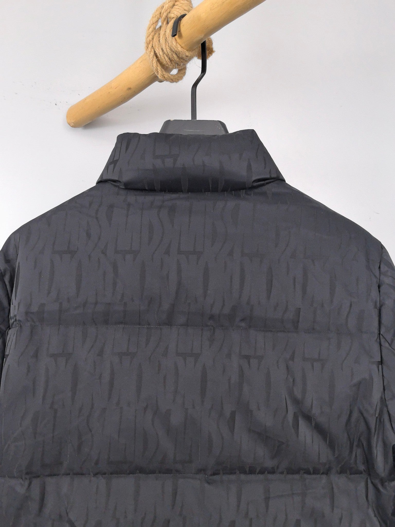 Prada dark quilted puffer jacket, back view with stand collar and quilted paneling