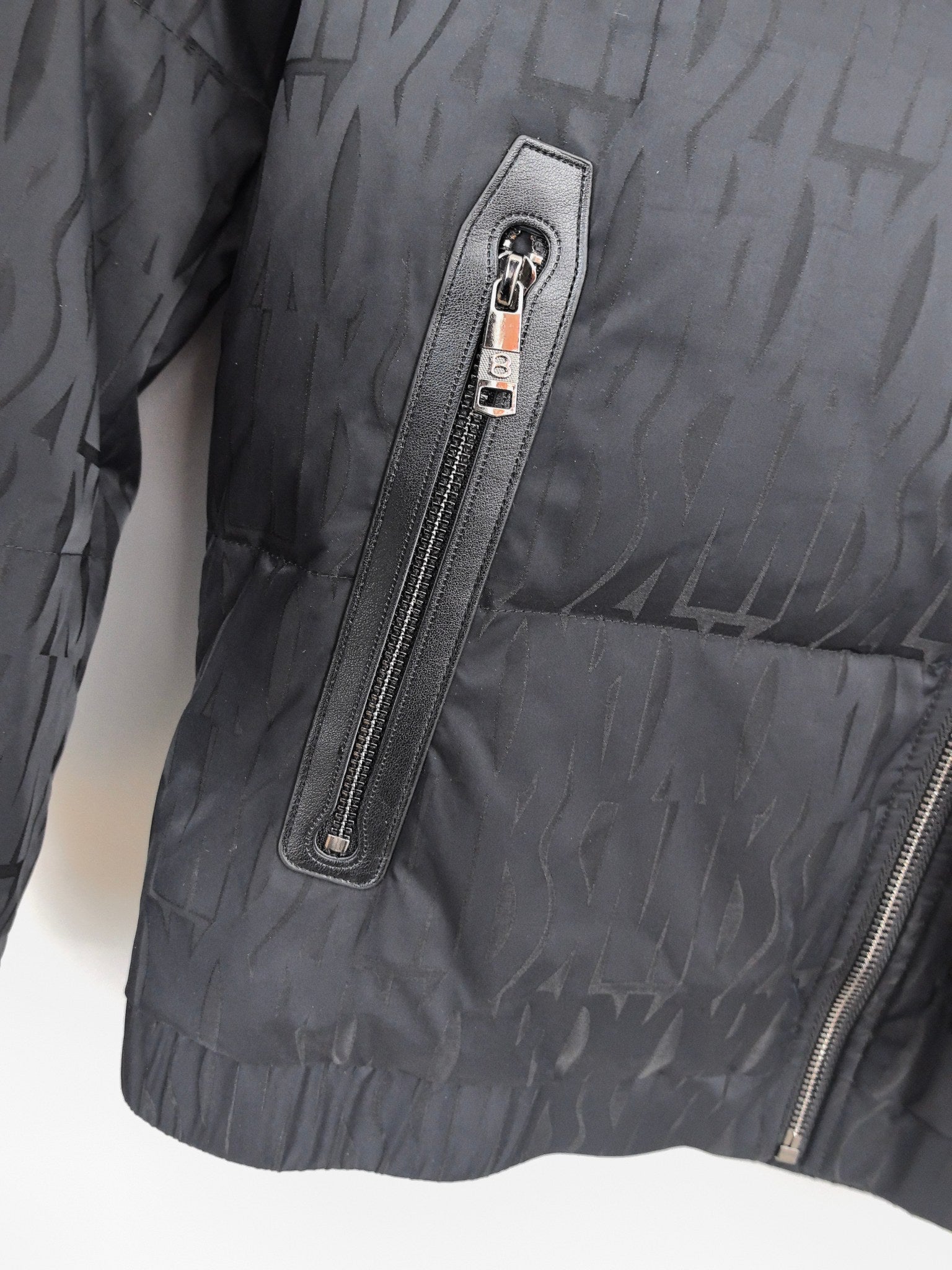 Prada puffer jacket detail: vertical chest zipper pocket with stitched label panel