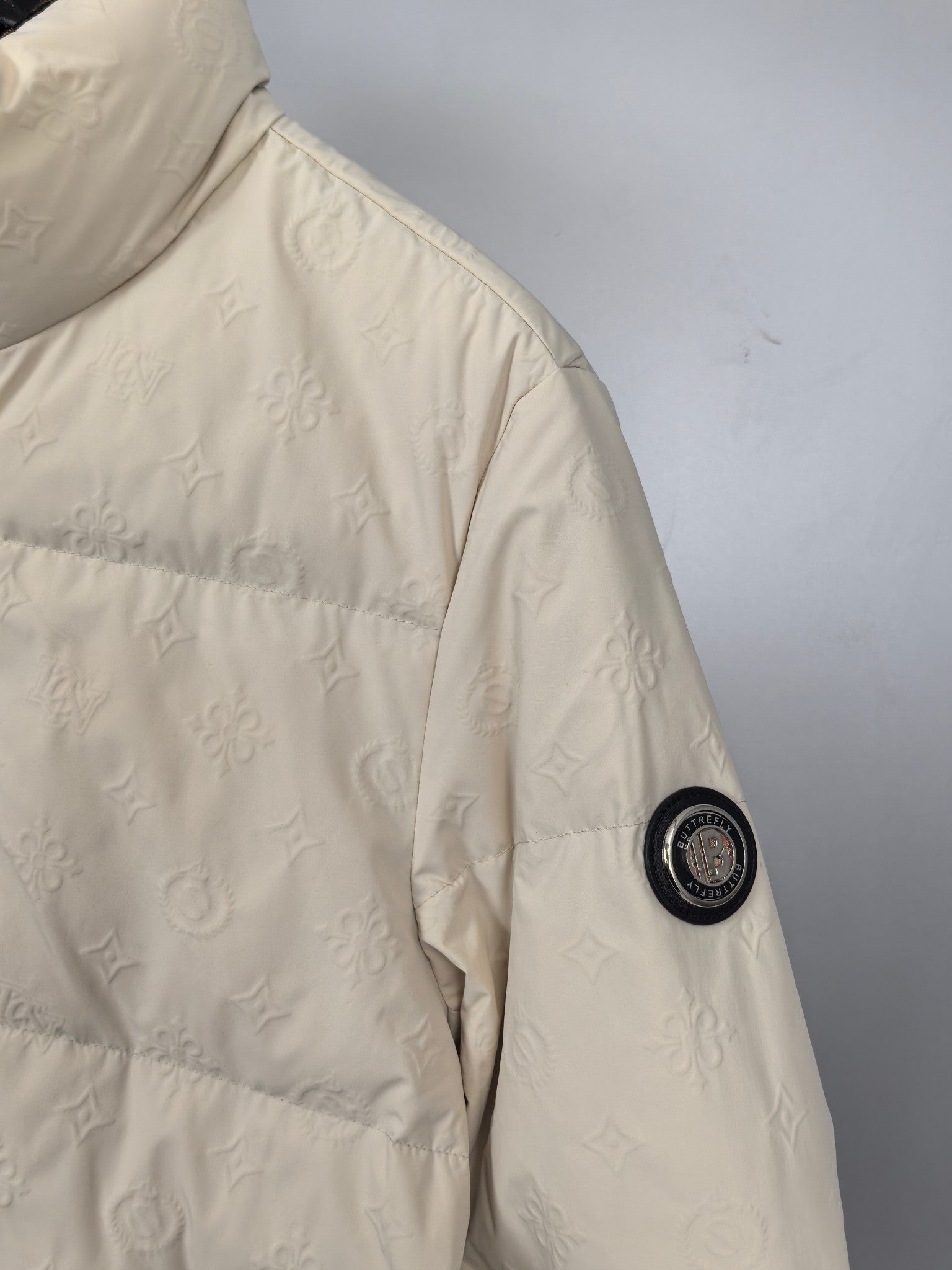 Burberry puffer jacket sleeve detail, cream textured logo pattern and snap button