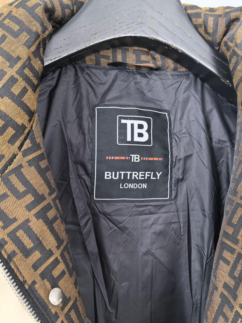 Burberry puffer jacket lining label, TB Butterfly London graphic on dark interior