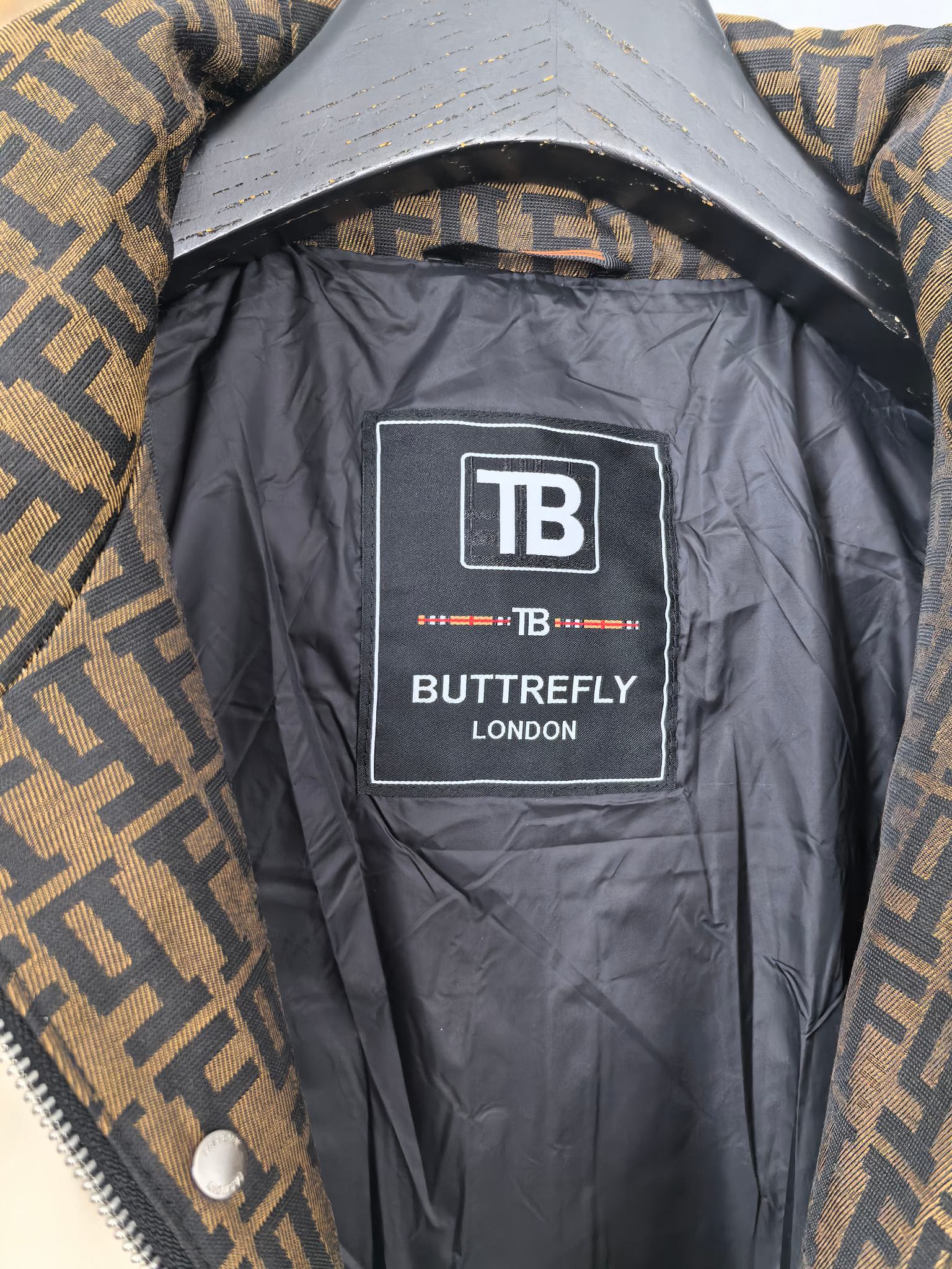 Burberry puffer jacket lining label, TB Butterfly London graphic on dark interior