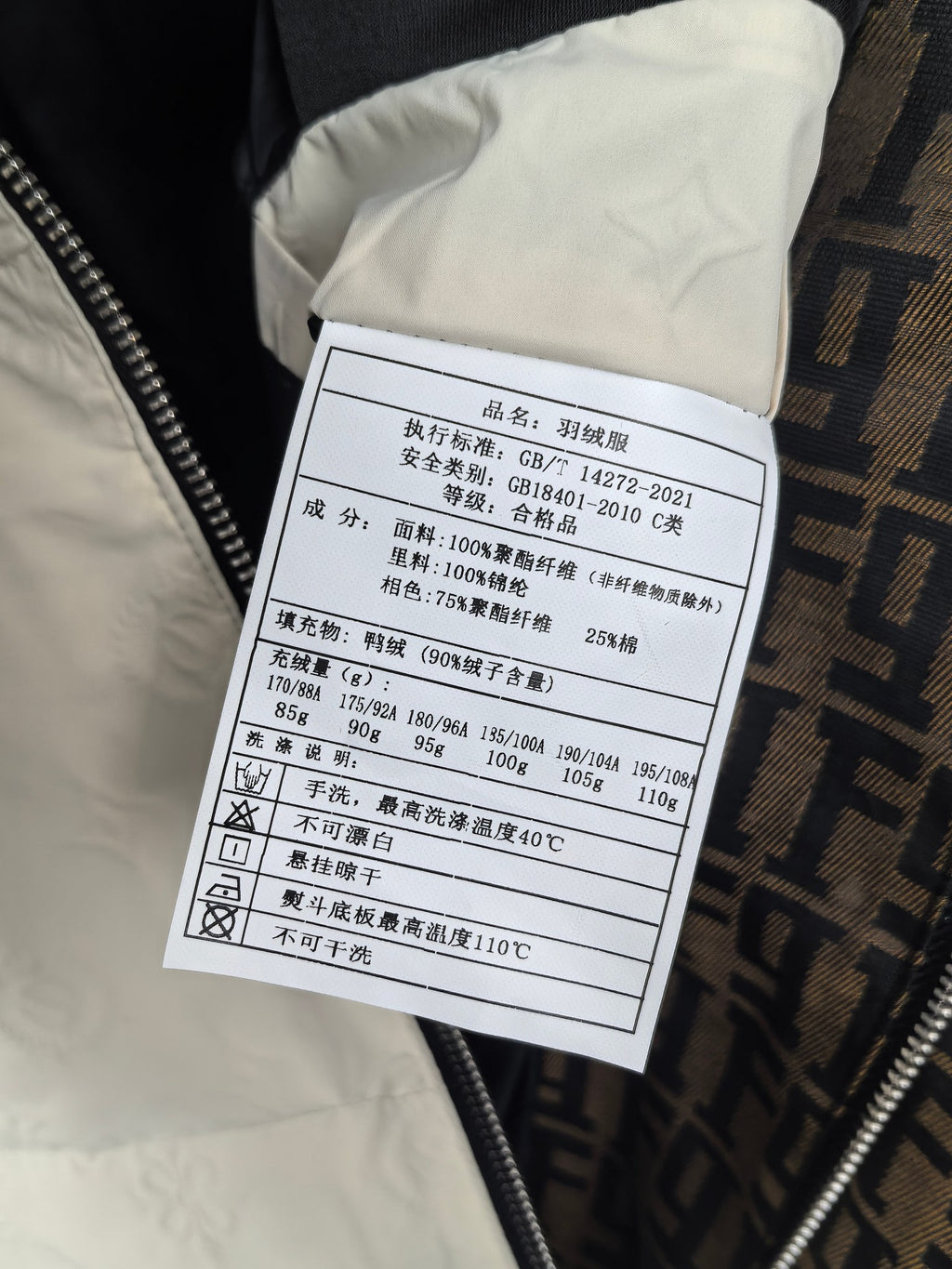 Burberry puffer jacket care label, size and material info on white tag