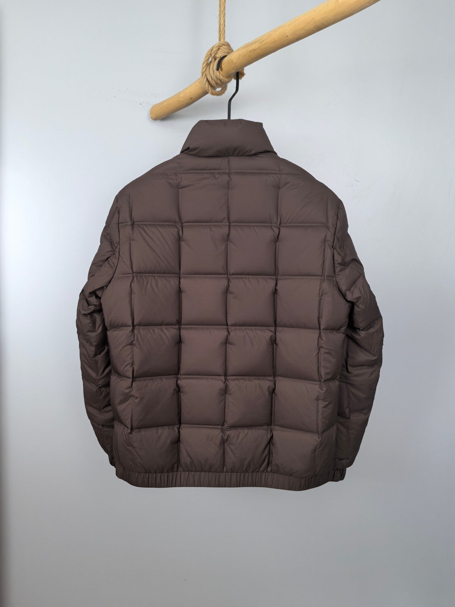 Brown puffer jacket back view with quilted panels and stand collar