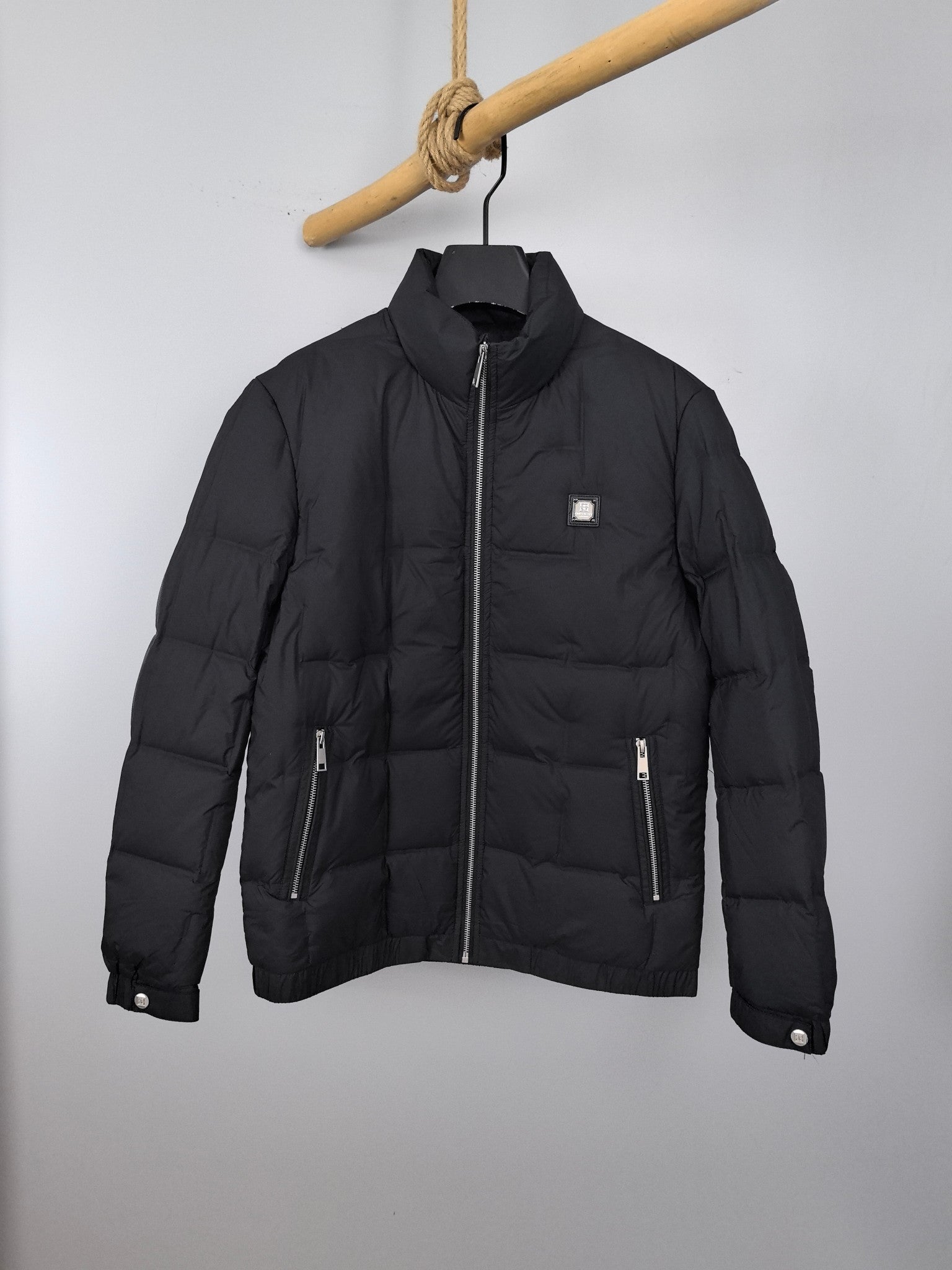 Black puffer jacket with full zipper, stand collar, two side zip pockets