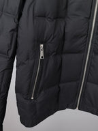 Black puffer jacket close-up showing center zip and quilted padded panels