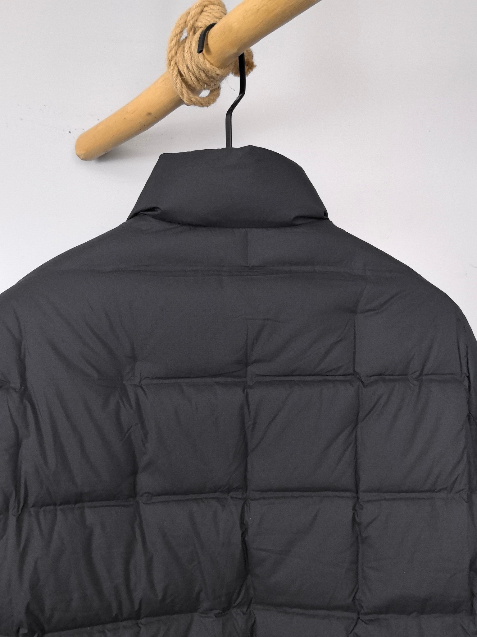 Black puffer jacket back view with stand collar and quilted insulation