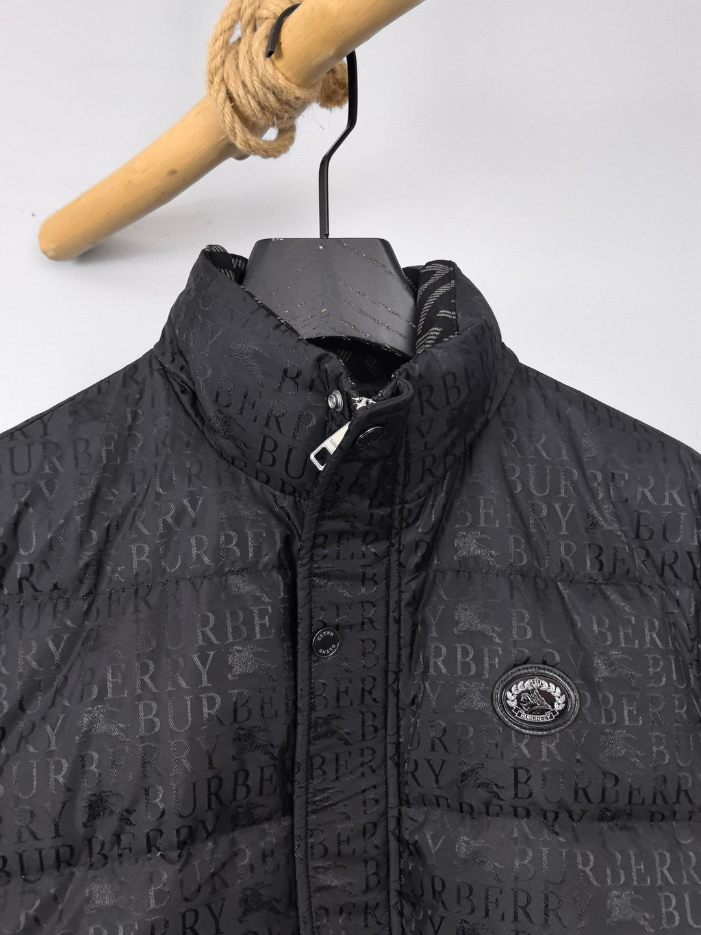 Long black puffer jacket with repeating logo pattern and zip placket