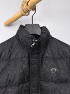 Long black puffer jacket with repeating logo pattern and zip placket