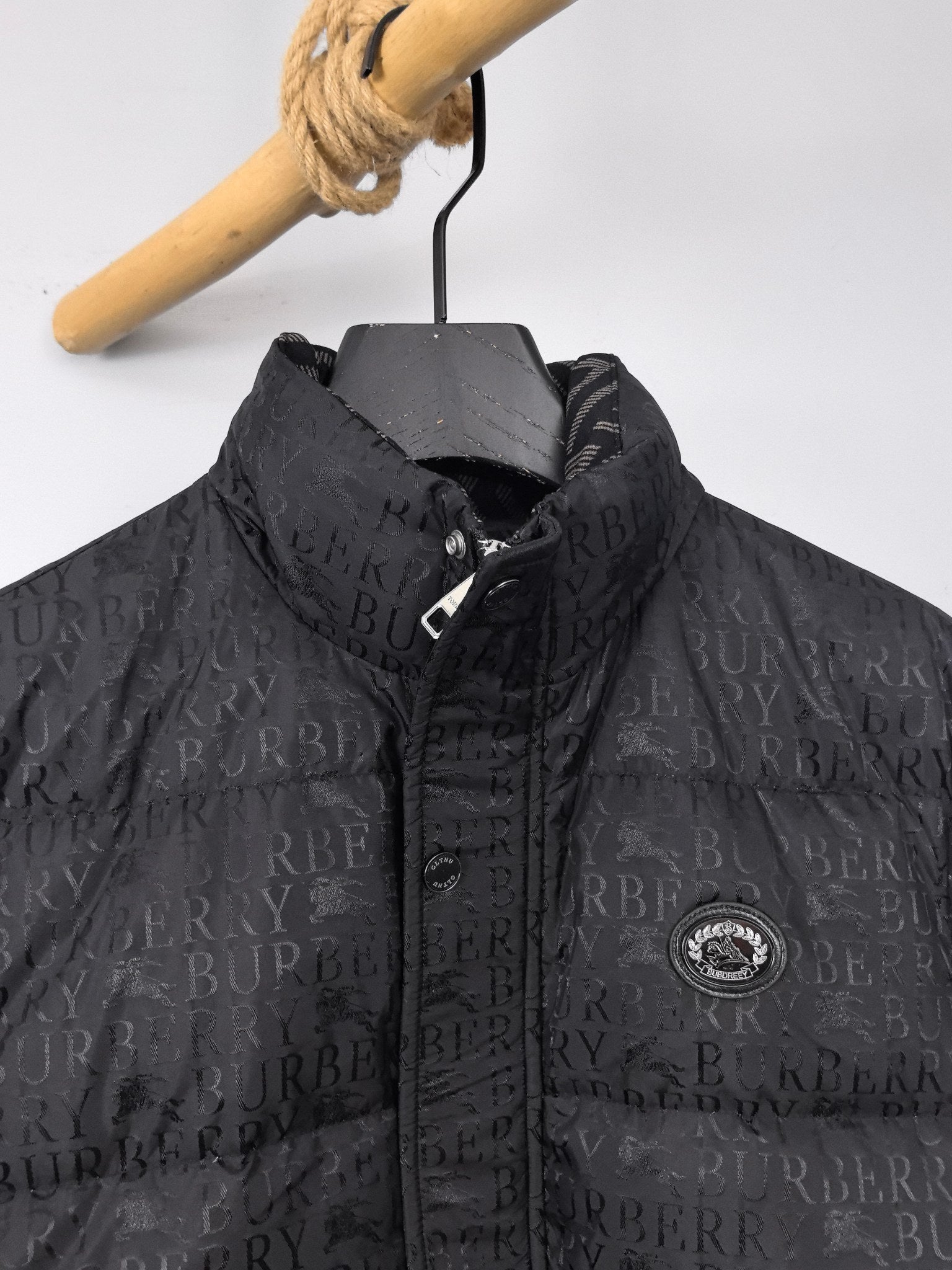 Long black puffer jacket with repeating logo pattern and zip placket