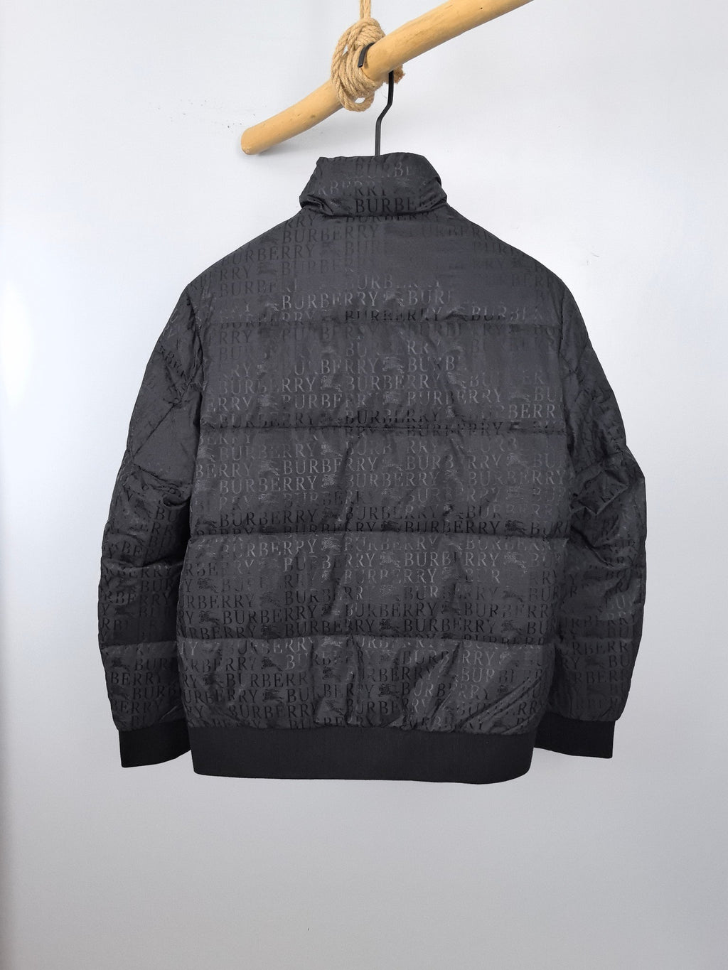 Long black puffer jacket back view with raised collar