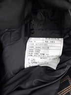 Black puffer jacket care label with size and article details