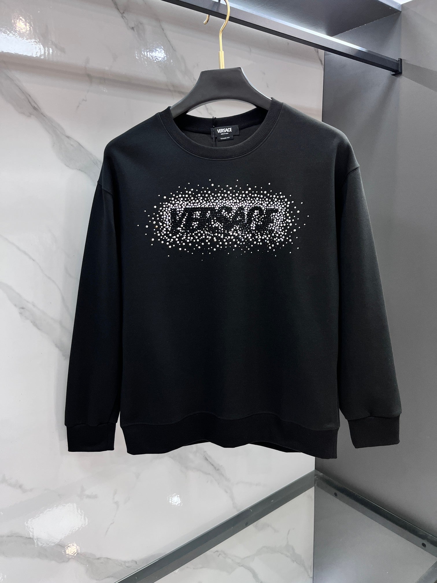 Black crewneck sweatshirt with rhinestone logo graphic on the chest