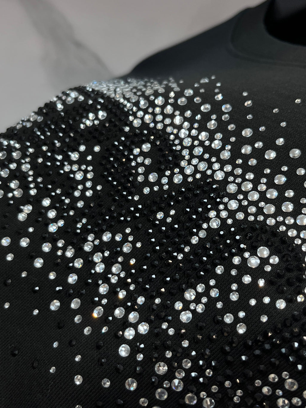 Black crewneck sweatshirt with dense rhinestone graphic on the front