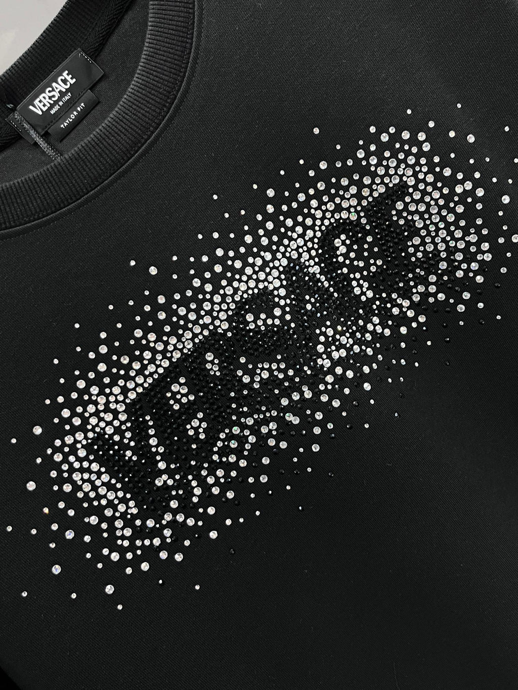 Versace sweatshirt chest close-up with rhinestone logo pattern