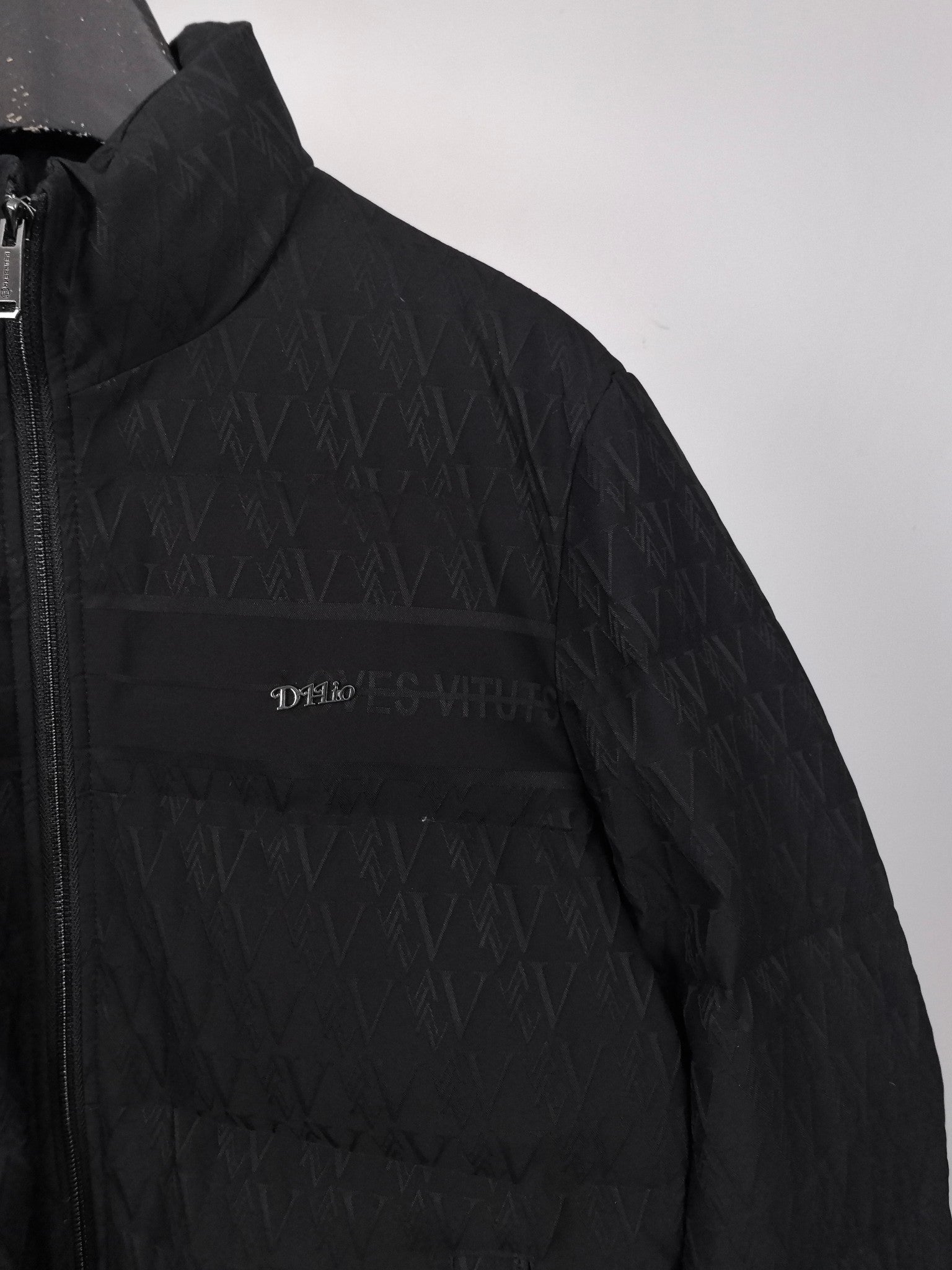 Black puffer jacket sleeve and chest panel with embroidered logo