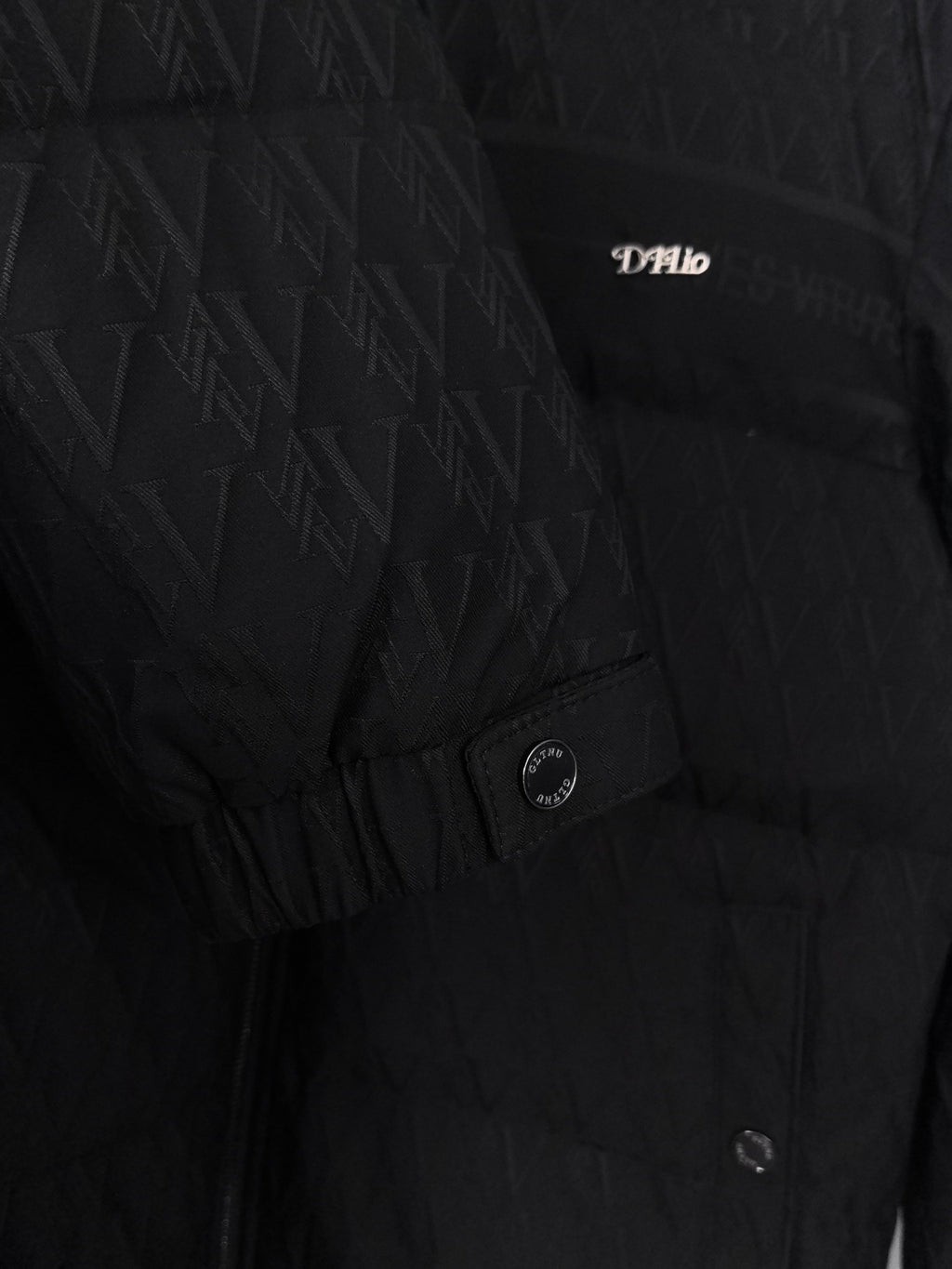 Black puffer jacket with monogram pattern and small chest logo