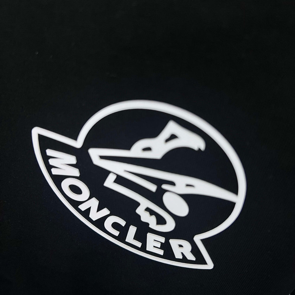 Moncler circular logo on black sweatshirt fabric close-up