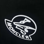 Moncler circular logo on black sweatshirt fabric close-up
