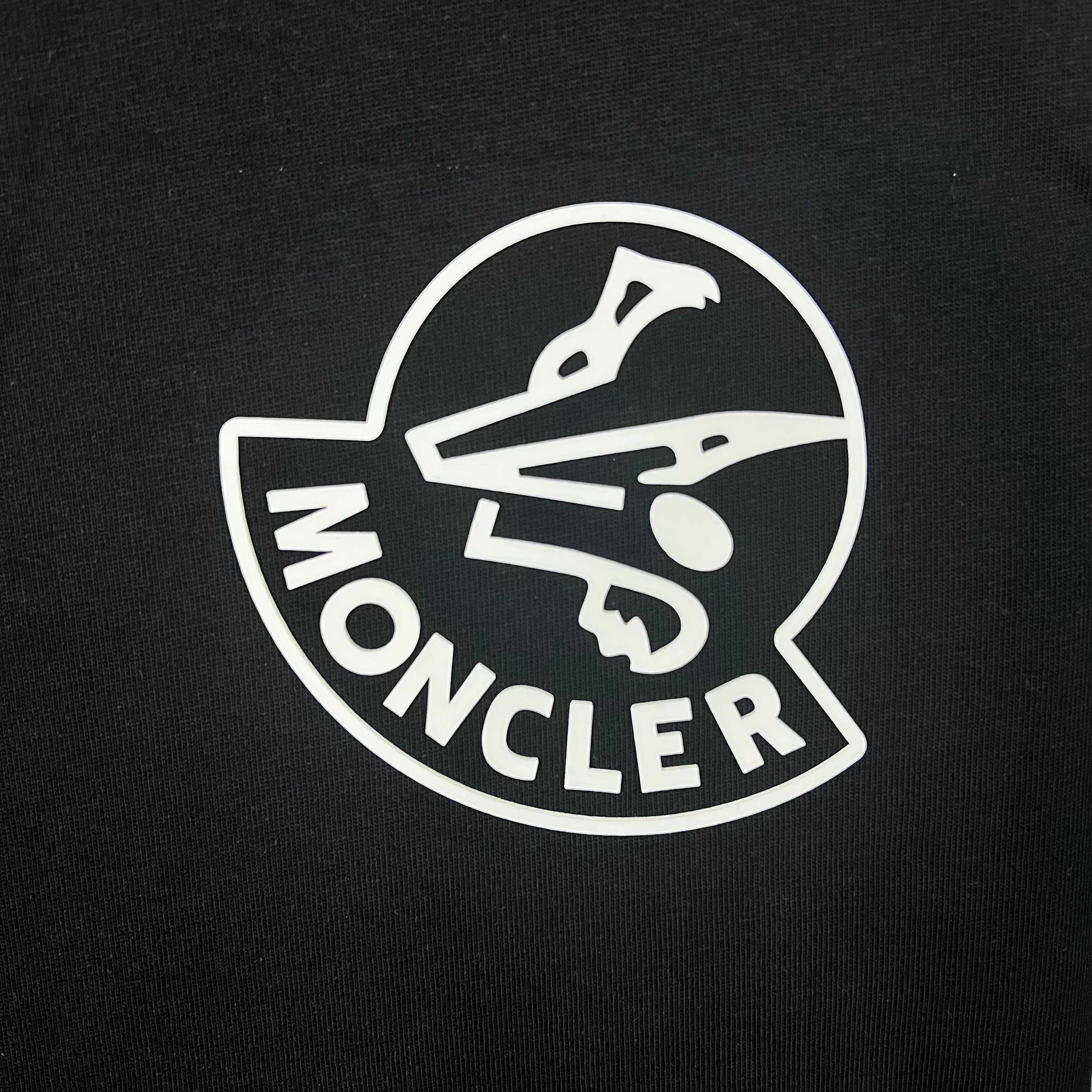 Moncler circular logo on black sweatshirt fabric