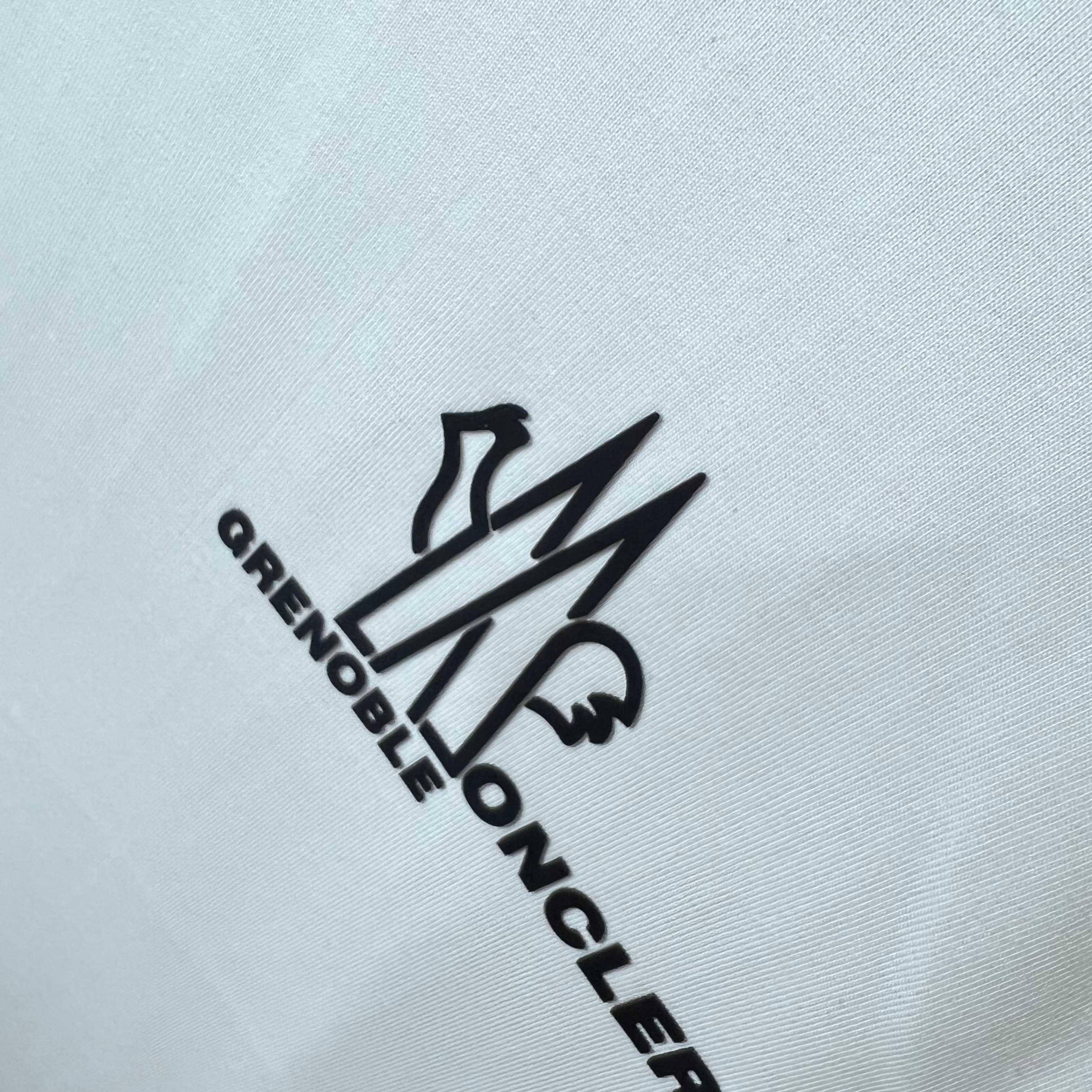 Moncler Grenoble logo graphic on white sweatshirt fabric