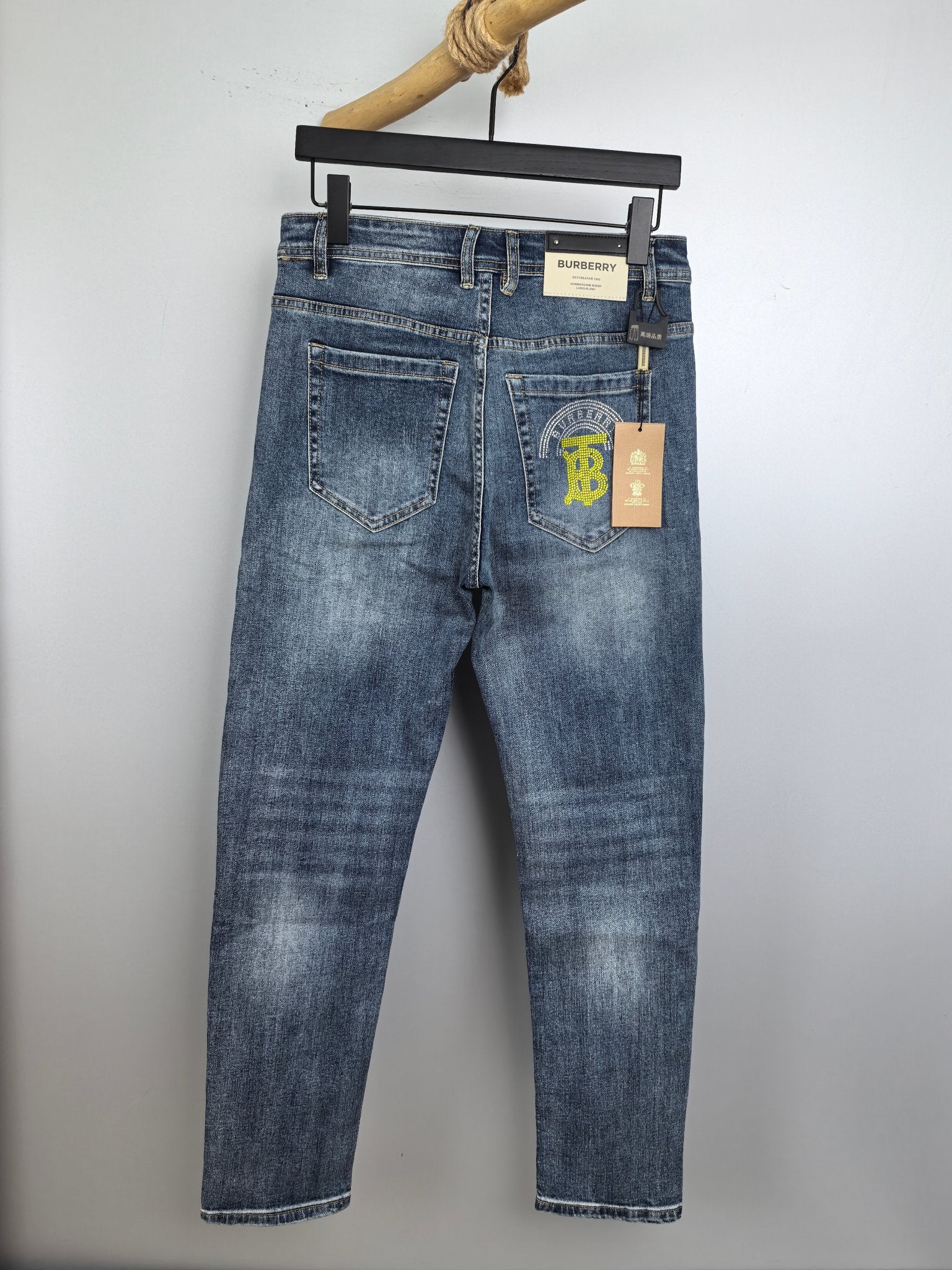 Denim pants on hanger, light wash with distressed areas and belt loops