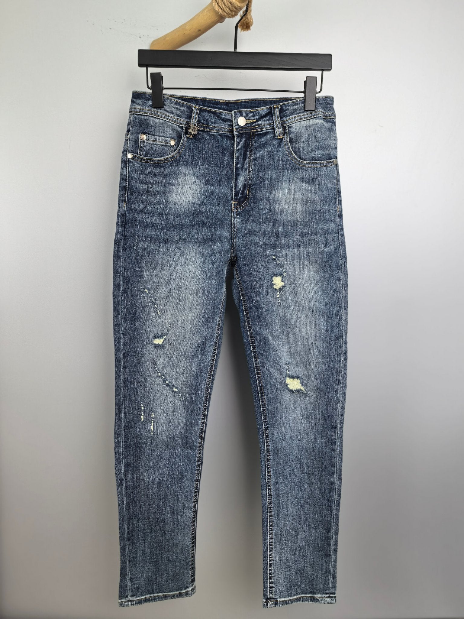 Denim pants with light wash and distressed patches, straight leg