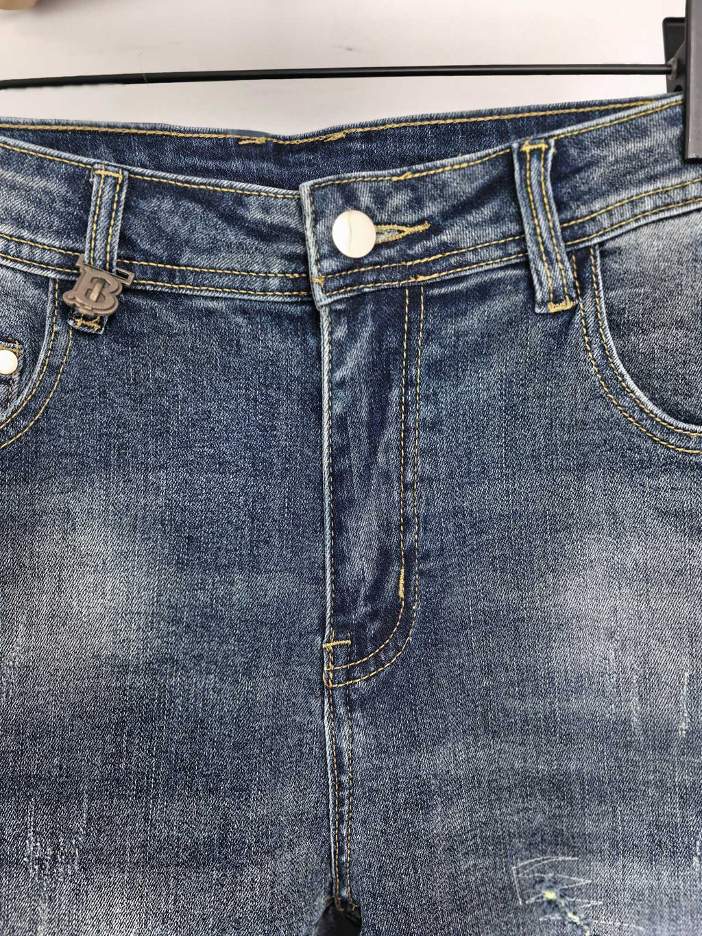 Denim pants waistband close-up with belt loops and button-front closure