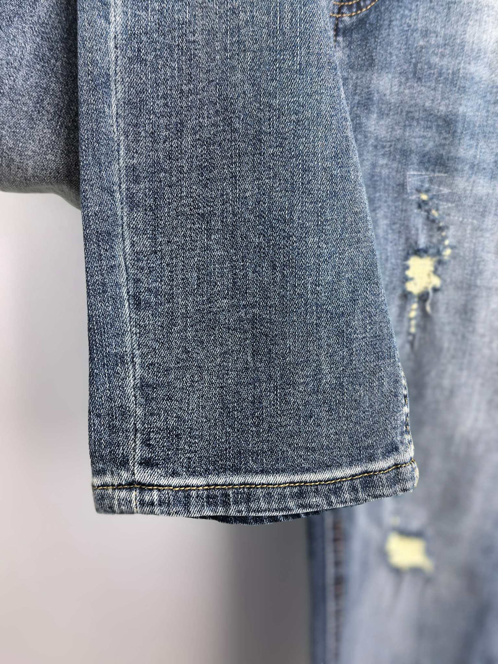 Denim pants hem and side leg with distressed yellow patch detail