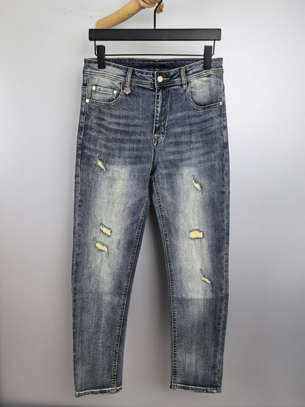 Givenchy blue denim jeans with distressed yellow patches, front view