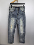 Givenchy blue denim jeans with distressed yellow patches, front view