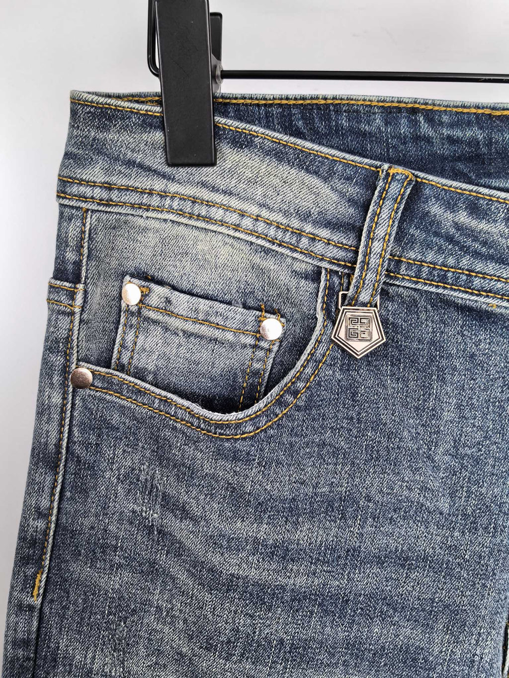 Givenchy denim jeans close-up of front pocket and stitched logo patch
