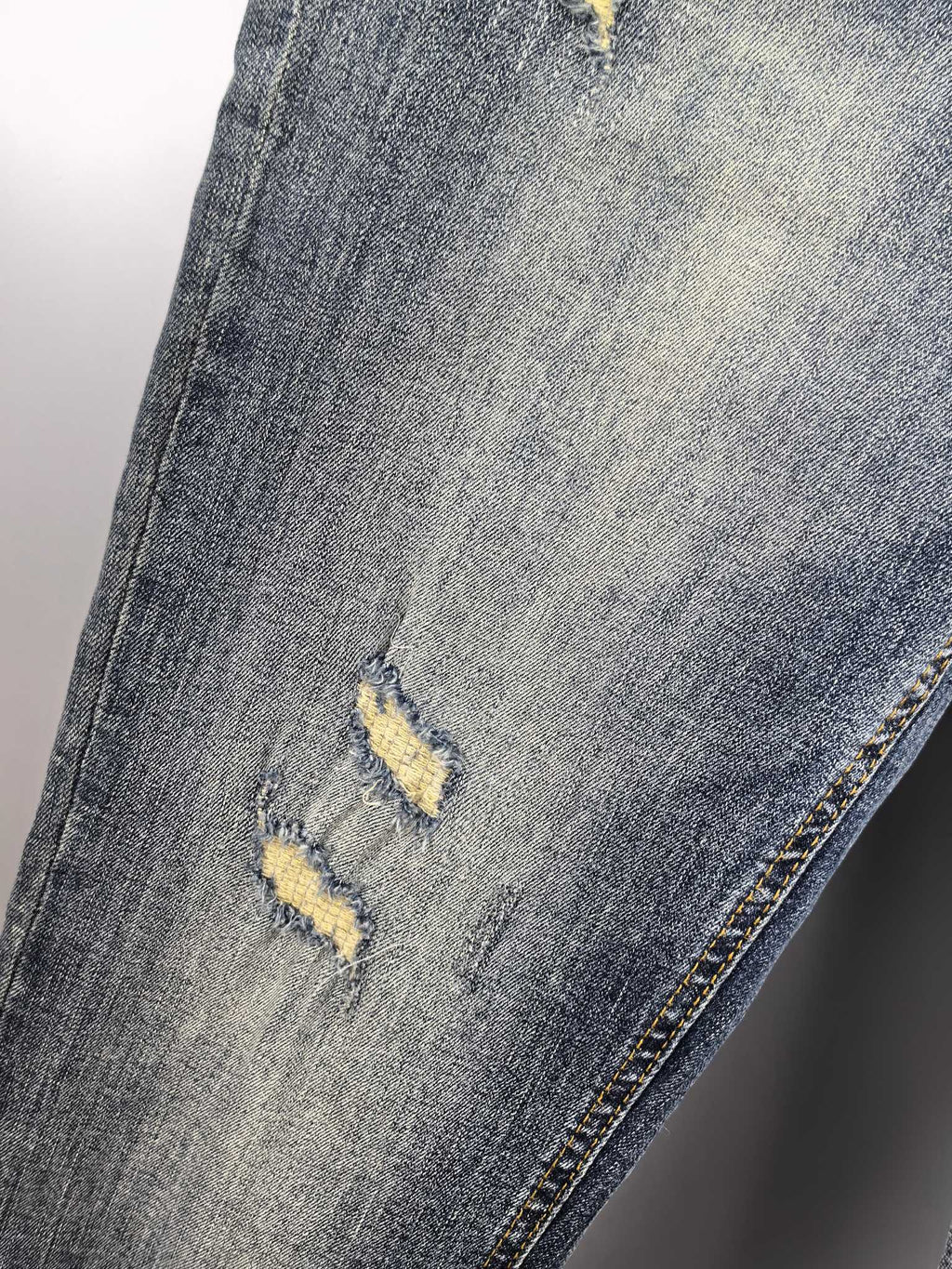 Givenchy blue denim jeans close-up of knee distress and yellow marks
