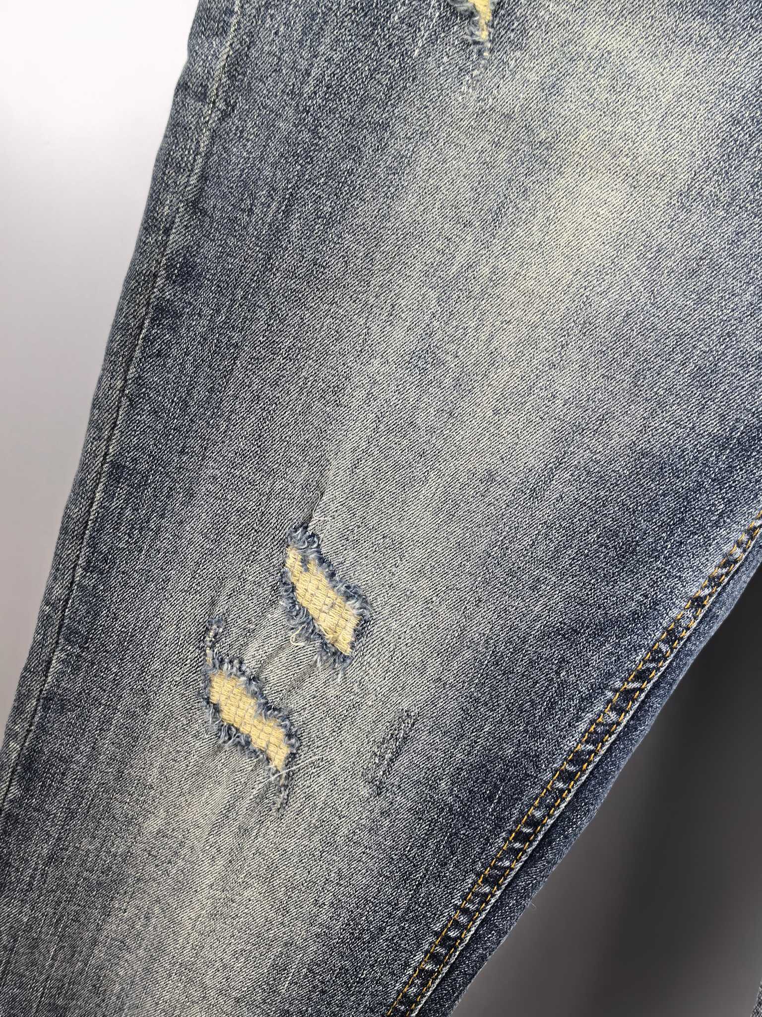 Givenchy blue denim jeans close-up of knee distress and yellow marks
