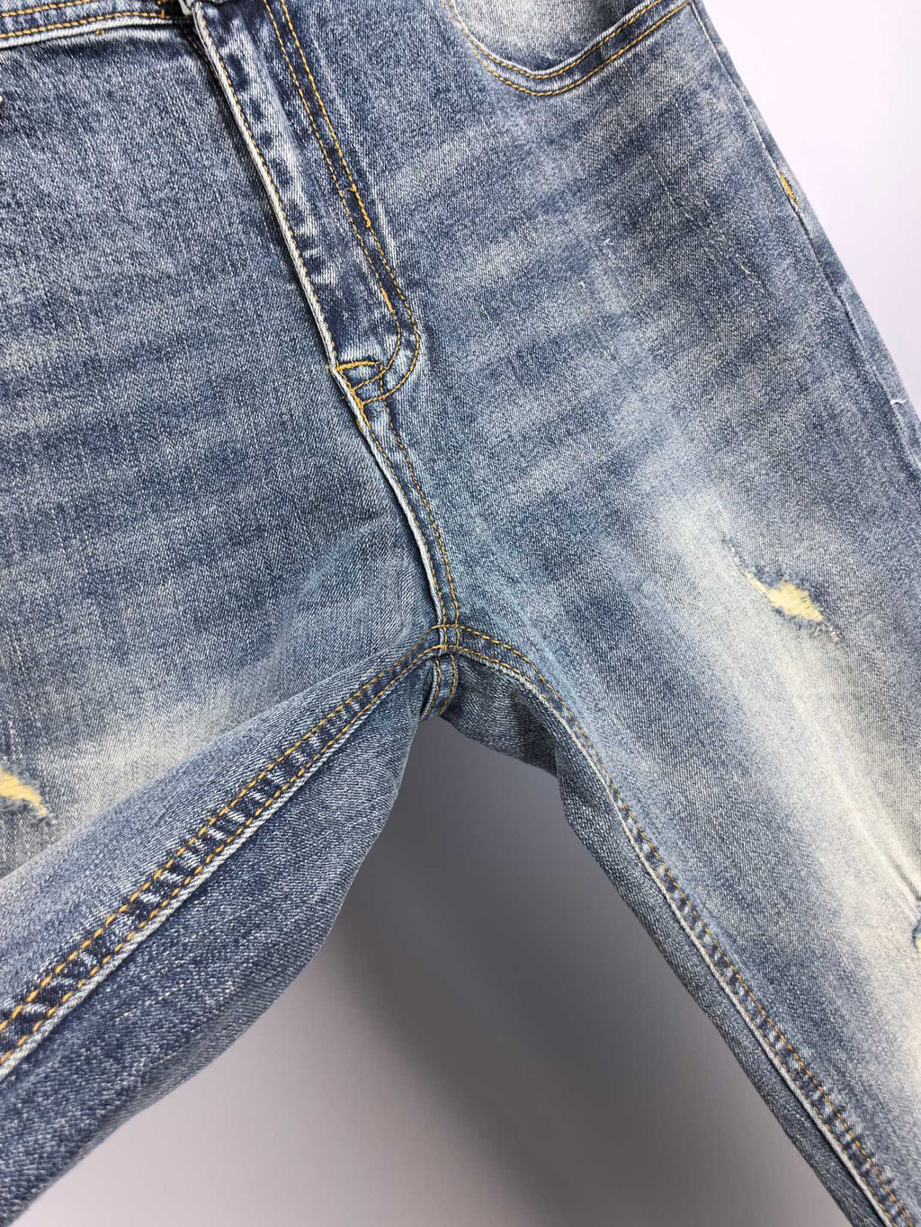 Givenchy blue denim jeans close-up of knee seam and distressed fabric