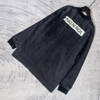 Balenciaga long-sleeve top angled, dark charcoal gray, BALENCIAGA logo on front