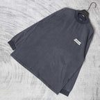 Balenciaga long-sleeve top laid flat, dark charcoal gray, small chest logo patch
