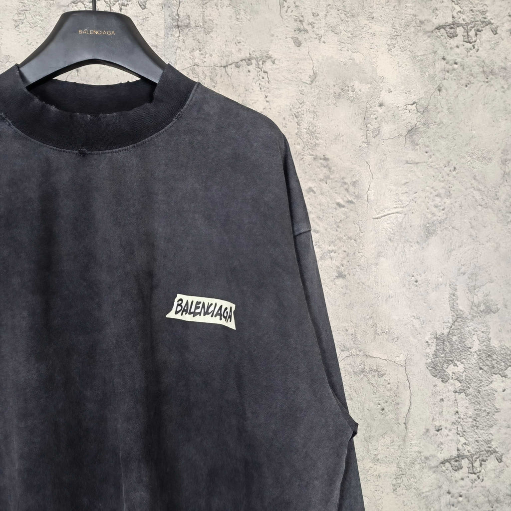 Balenciaga long-sleeve top side view, dark charcoal gray, small BALENCIAGA logo patch