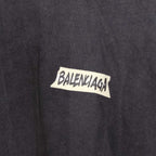 Balenciaga long-sleeve top logo closeup, dark charcoal gray with BALENCIAGA lettering