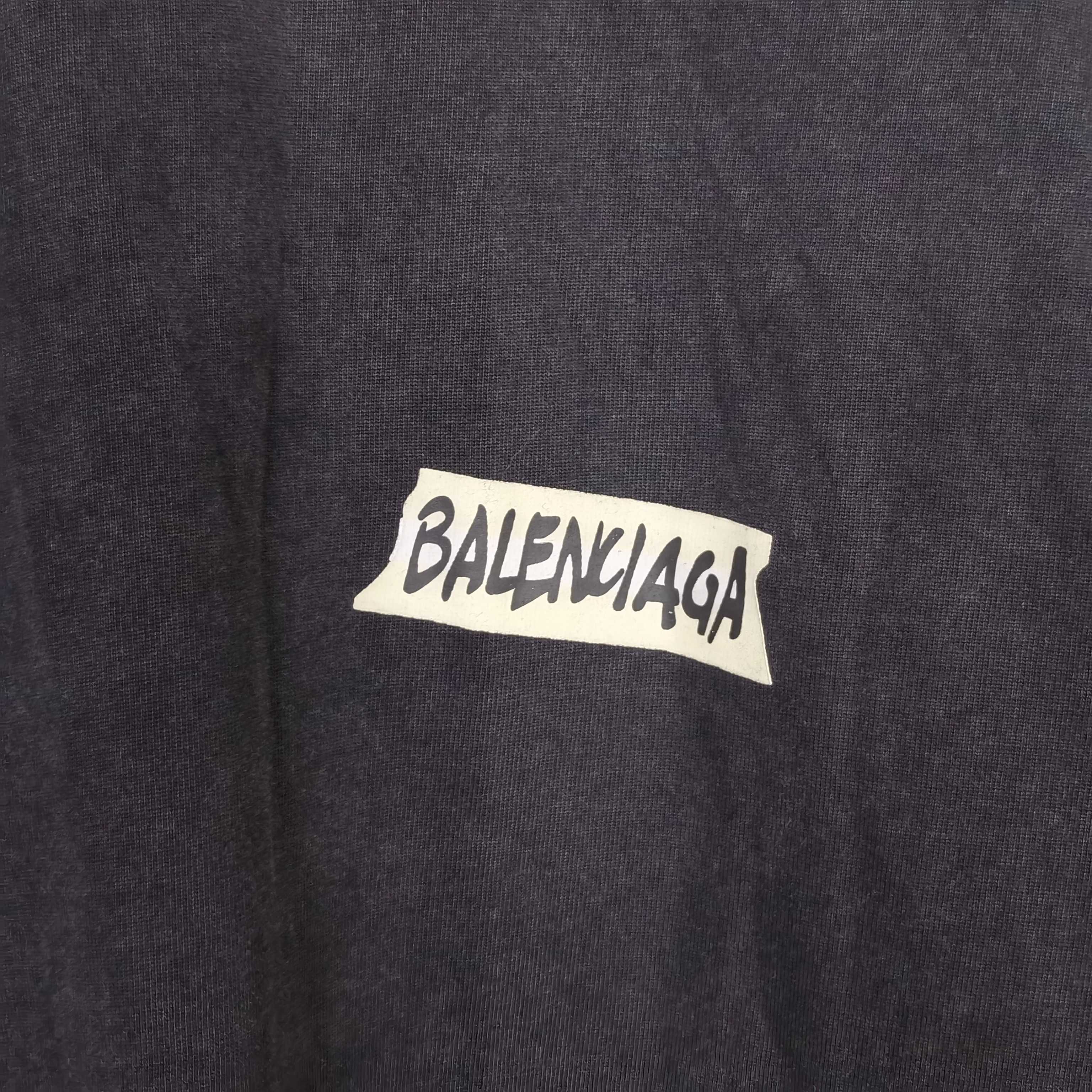 Balenciaga long-sleeve top logo closeup, dark charcoal gray with BALENCIAGA lettering