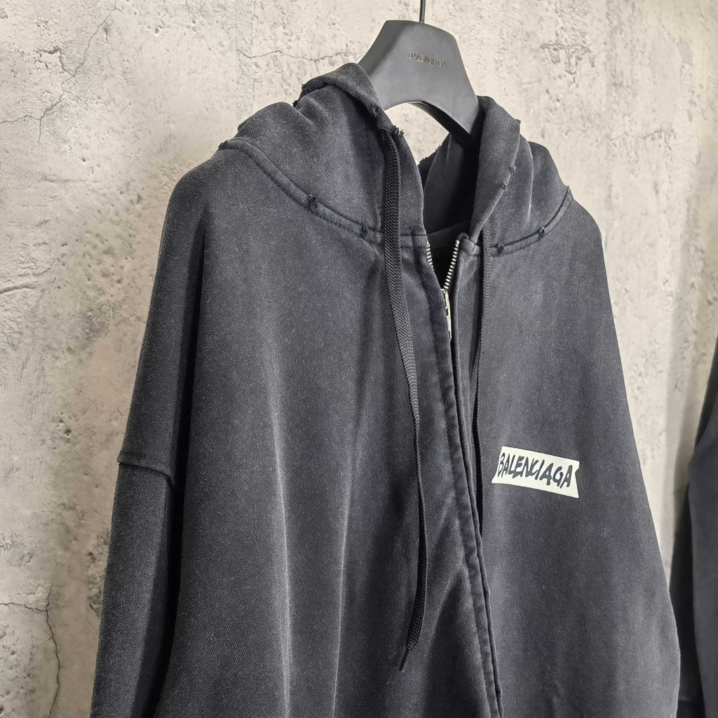 Black zip-up hoodie jacket with hood, front zipper, and chest logo patch