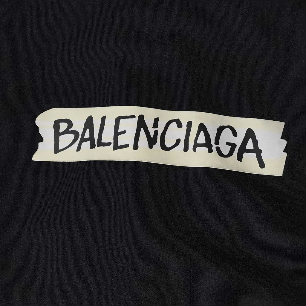Close-up of BALENCIAGA logo patch on black hoodie fabric