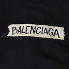 Close-up of BALENCIAGA logo patch on black hoodie fabric