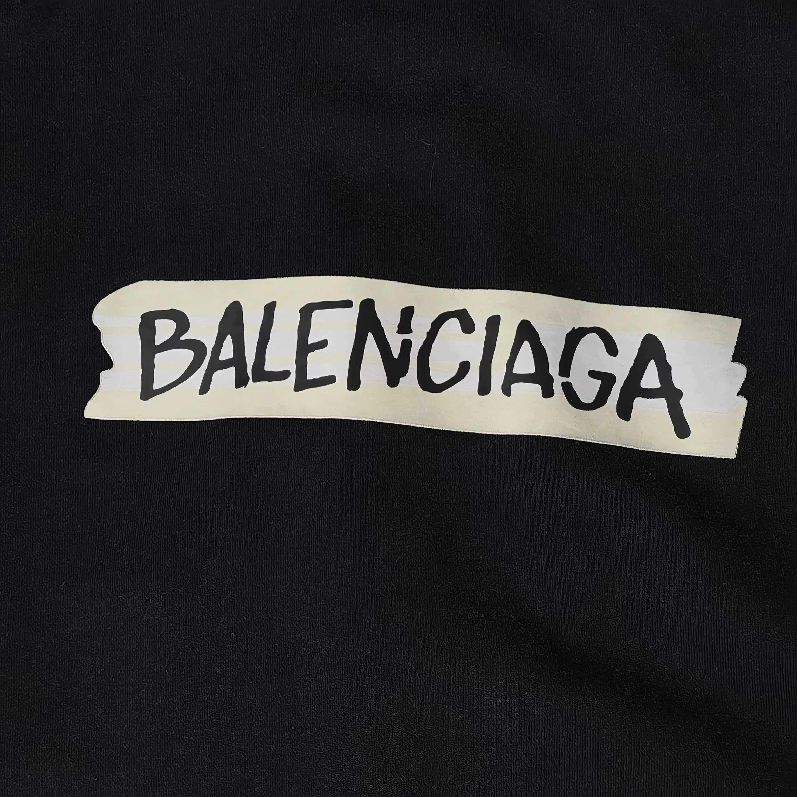 Close-up of BALENCIAGA logo patch on black hoodie fabric