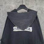 Dark zip-up hoodie jacket with hood and large back logo text