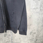 Zip-up hoodie sleeve detail with kangaroo pocket seam, dark blue