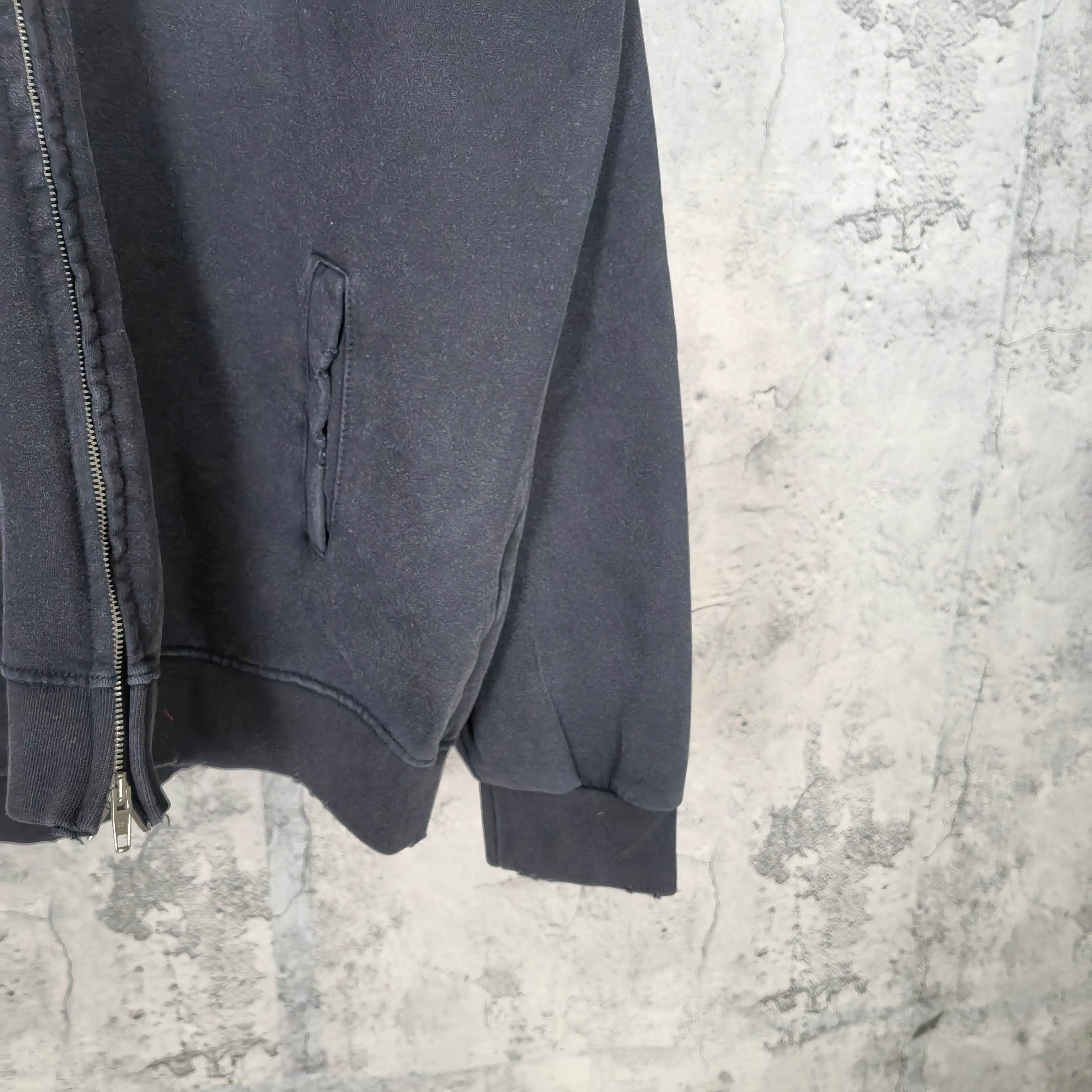 Zip-up hoodie sleeve detail with kangaroo pocket seam, dark blue