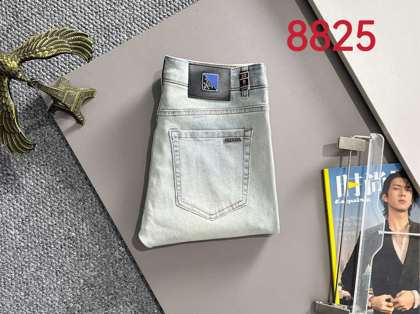 Light-wash denim pants on hanger with belt loops and front pockets