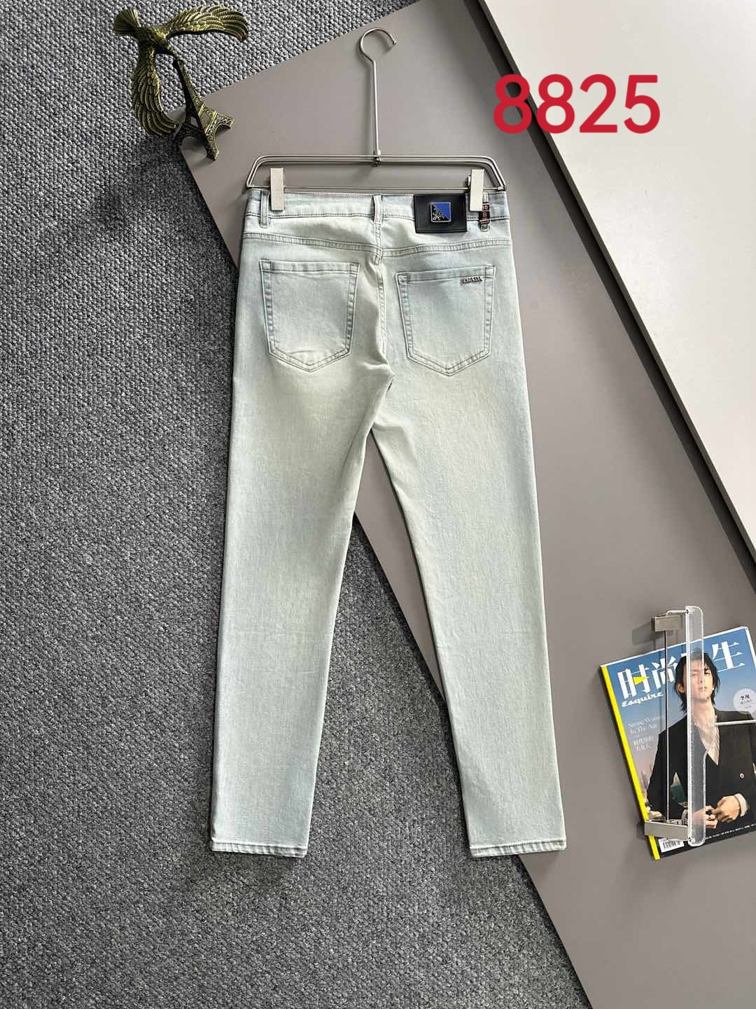 Light-wash denim pants on hanger with belt loops and front pockets