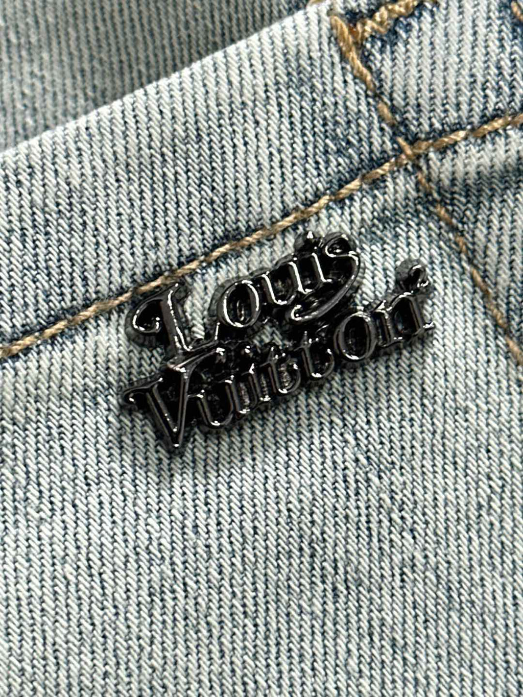 Denim fabric with LV logo metal embroidery and gold-tone stitching detail
